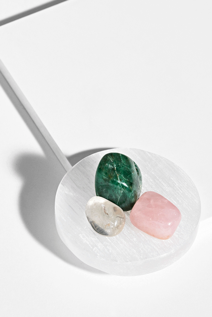 Hvid Selenit Plade med tre sten til opladning, vist på hvid baggrund