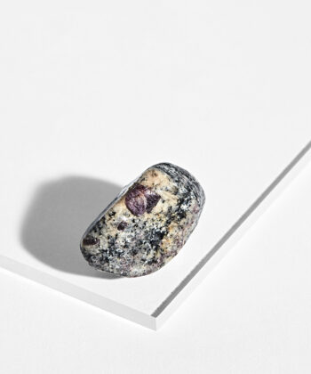 Cremefarvet Rubin Granit med lilla og sorte detaljer på hvid baggrund