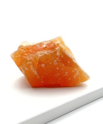 Rå orange krystal på hvid baggrund