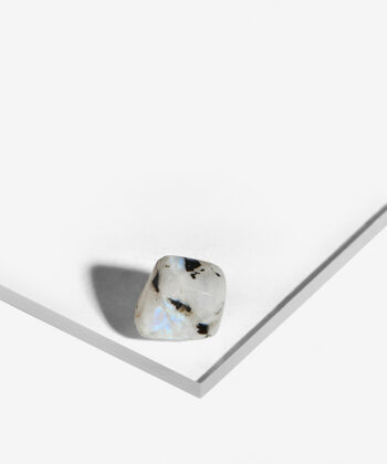 Hvid Regnbue Månesten med smukke iriserende elementer og sorte detaljer på hvid baggrund