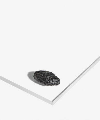 Sort semiblank Tektit med taktil overflade på hvid baggrund